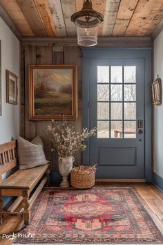 a room with a blue door and a rug on the floor next to a bench