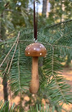 a mushroom ornament hanging from a pine tree