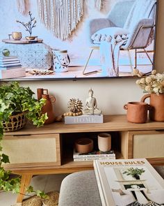 a living room filled with lots of furniture and plants on top of a wooden table