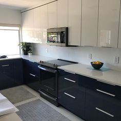 a kitchen with black cabinets and white counter tops