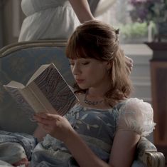 a woman sitting in a chair reading a book