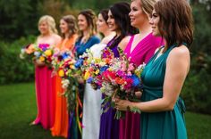 a group of women standing next to each other holding bouquets in front of them