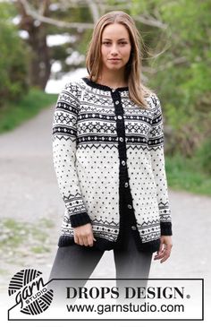 a woman standing in the middle of a road wearing a black and white cardigan