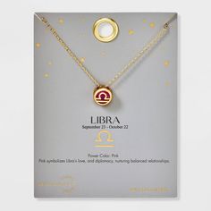 the zodiac sign libra necklace is displayed in front of a card with gold stars