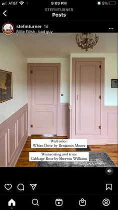 a room with pink painted doors and wood flooring on the walls, in front of a chandelier