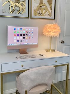 a desk with a computer, chair and pictures on the wall