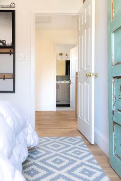 a bedroom with white walls and wooden floors