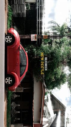 a red car parked next to a tall building