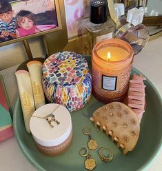 an assortment of personal care items on a tray next to candles and other decorative items