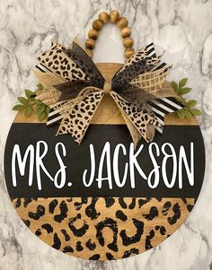 a wooden sign that says mr and mrs jackson with a leopard print bow on it