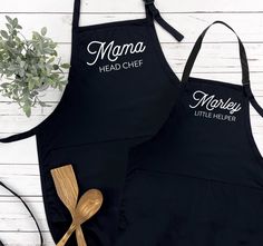 two black aprons with the words mama head chef and little helper on them