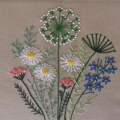 the embroidery is done with different colors and designs on it, including daisies and other flowers