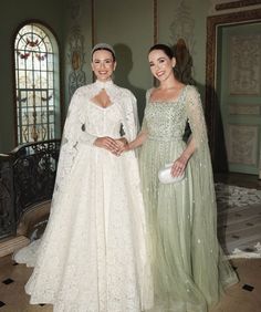 two women standing next to each other in dresses