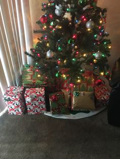 a small christmas tree with presents under it