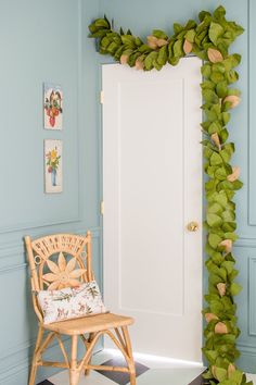 a chair sitting in front of a door with a green plant on it's side