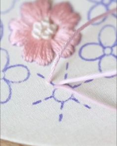 a close up of a piece of fabric with a flower on it and some thread