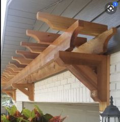 a wooden bench sitting on top of a porch next to a planter filled with flowers