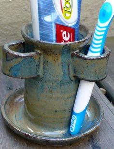 two toothbrushes in a cup on a table