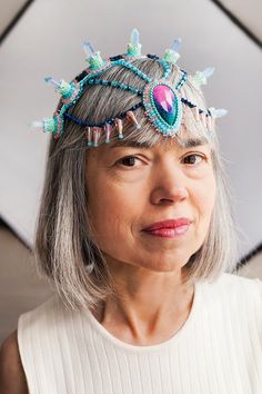 an older woman with grey hair wearing a tiara