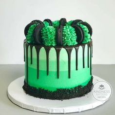 a green and black cake with oreo cookies on top