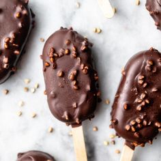 chocolate covered ice cream pops with sprinkles and nuts on the top one