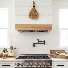 a stove top oven sitting inside of a kitchen next to white cabinets and counter tops