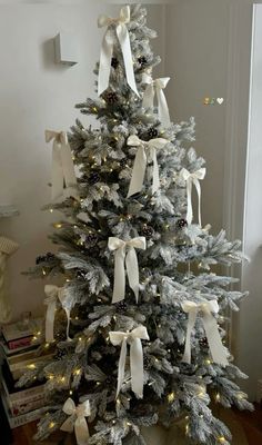 a white christmas tree with bows and lights