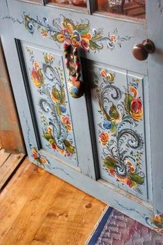 the door is painted blue and has floral designs on it, as well as an ornate handle