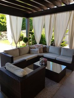 an outdoor living area with couches and tables