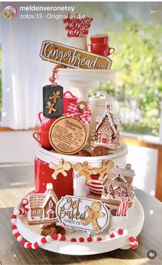 a christmas cake with gingerbread cookies and other treats on it's tiered tray