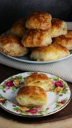 a plate full of pastries sitting on a table next to another plate filled with biscuits