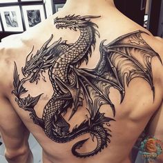 a man's back with a dragon tattoo on his upper and lower half body