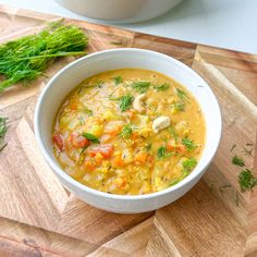 a white bowl filled with soup on top of a wooden cutting board