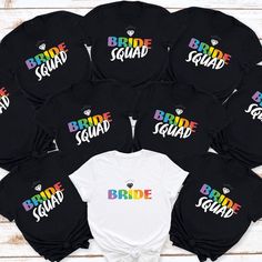 the bride squad shirts in black and white are arranged on top of each other with rainbow letters