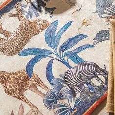 a close up of a rug with animals and plants on it, including zebras