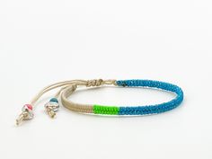 This beige bracelet with glitter blue yarn is comfortable to wear and lightweight around the wrist with adjustable sliding knot closure so fits most sizes both women, men and children. It harmonizes with every outfit, every occasion, also perfect as a gift for your loved ones. Wrapped length 13cm, extension braided length 11cm, width 0.4cm Designed and made in a smoke free - pet free environment.  All our products are nickel free and kind to the skin.  Each bracelet is unique and handmade, there Blue Macrame Beaded Bracelets For Festival, Blue Bohemian Friendship Bracelets For Summer, Bohemian Blue Friendship Bracelets For Summer, Blue Macrame Hippie Jewelry, Hippie Blue Macrame Jewelry, Blue Hippie Macrame Jewelry, Blue Macrame Bracelets For Festival, Green Bohemian Braided Bracelets With Adjustable Length, Adjustable Blue Beaded Bracelets In Hippie Style