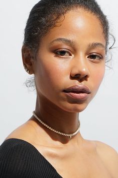 a close up of a woman wearing a choker and necklace with her eyes closed