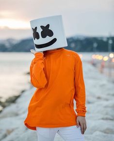 a person wearing an orange shirt with a white mask on their head