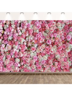 a large flower wall in an empty room with wooden flooring and lights on the side