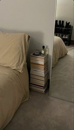 a bedroom with a bed, nightstand and mirror in the corner next to each other