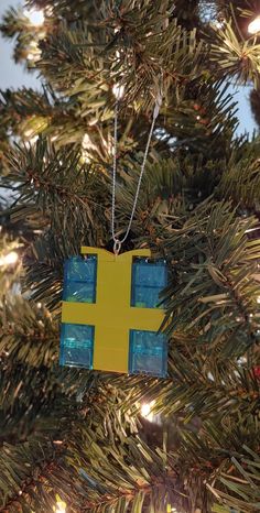 a yellow and blue ornament hanging from a christmas tree