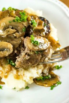 a white plate topped with mashed potatoes and mushrooms