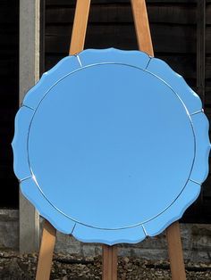 a blue mirror sitting on top of a wooden easel