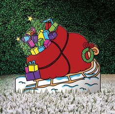 a christmas sleigh with presents on it is in the middle of some grass