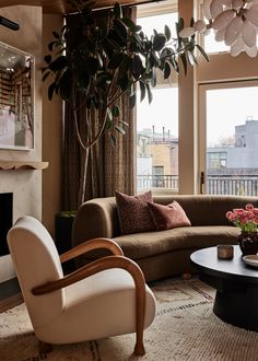 a living room filled with furniture and a fire place in front of a large window