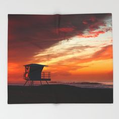 a towel with a lifeguard tower at sunset