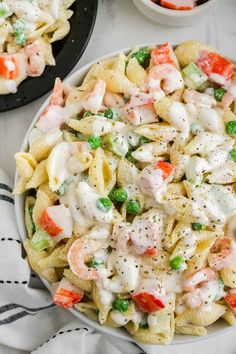 pasta salad with shrimp and peas in a white bowl