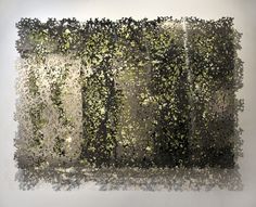 an abstract painting with green and black paint on the wall, in front of a white background