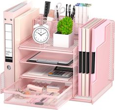 a pink desk organizer with lots of office supplies on top of it and a clock in the middle