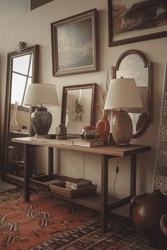 a table with two lamps and pictures on the wall behind it in front of a mirror